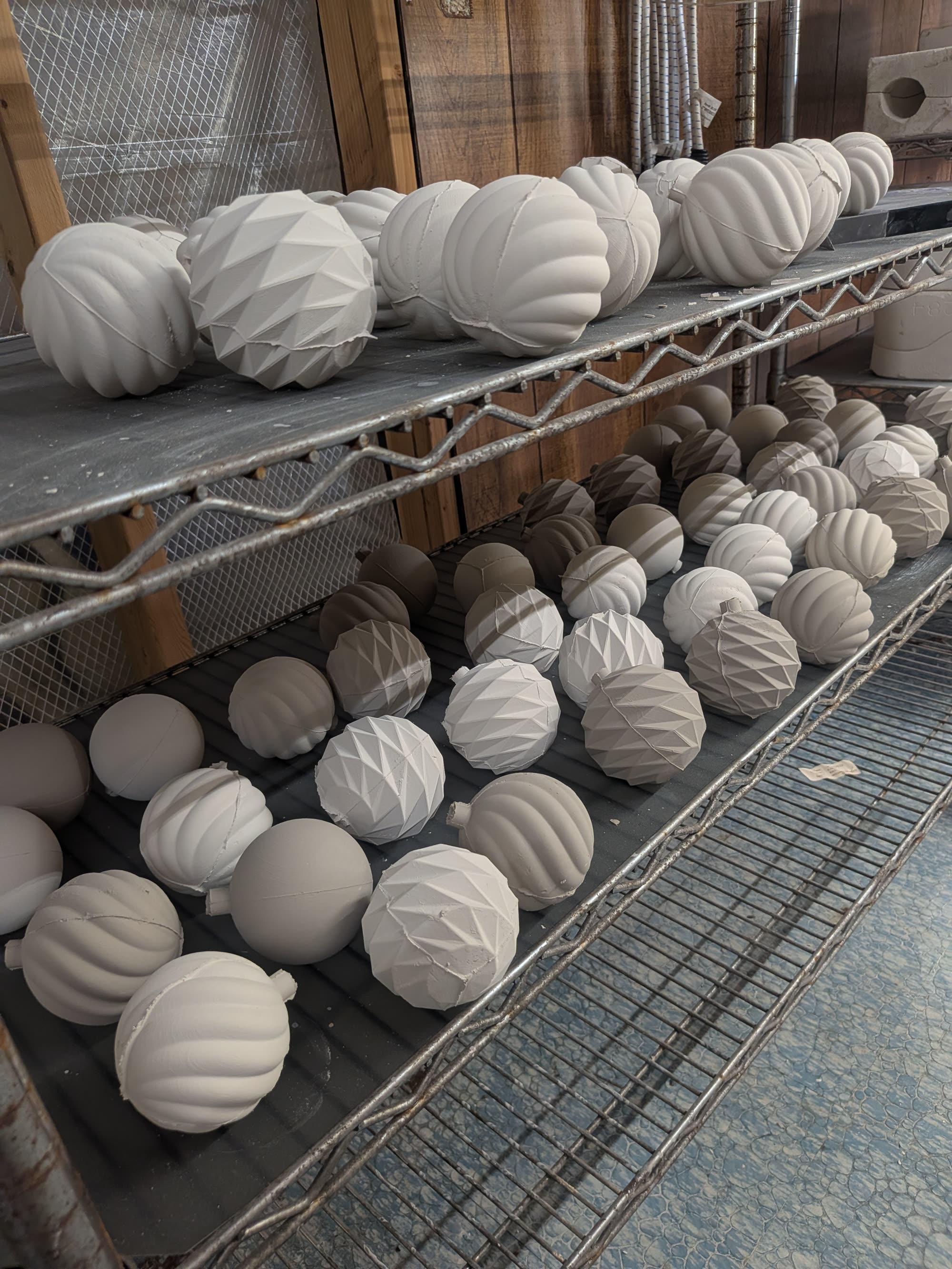 Rows of pale ribbed ceramic ornaments lined up on a shelf.
